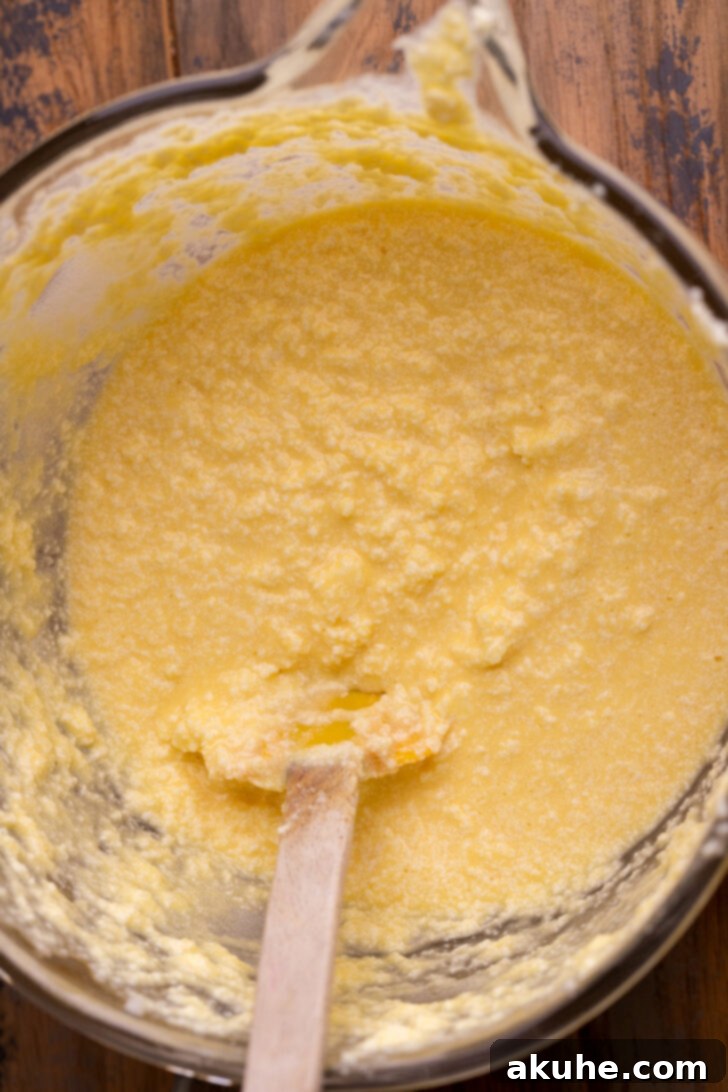 Blueberry Bliss Cake 4 Wet ingredients in a mixing bowl, showcasing the chunky texture from sour cream, indicating normal consistency before dry ingredients are added.