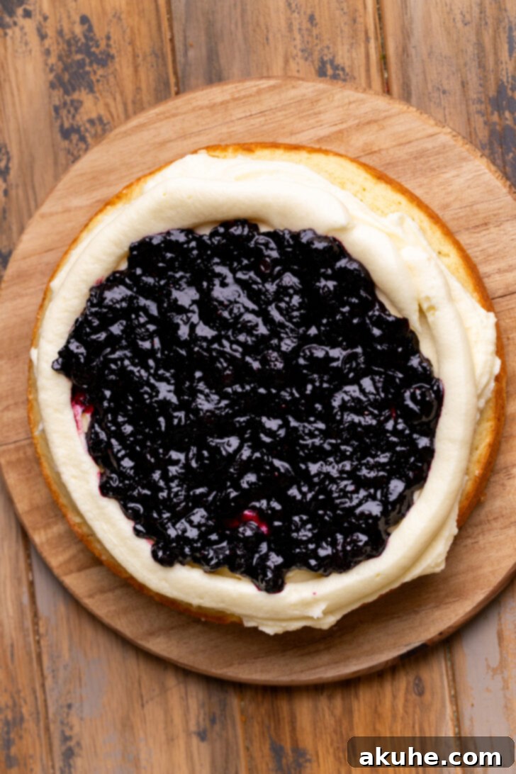 Blueberry Bliss Cake 10 Vibrant blueberry jam carefully spread within the frosting border on a cake layer.