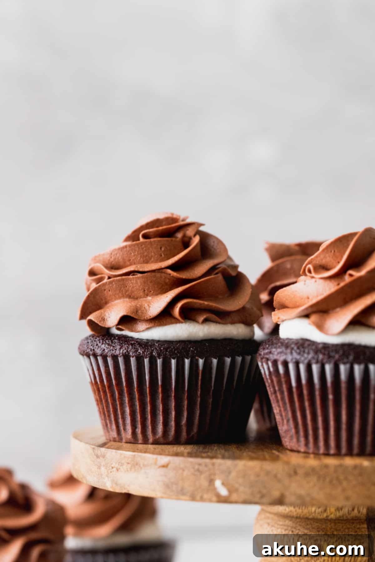 Multiple hot chocolate cupcakes arranged on an elegant cake stand.