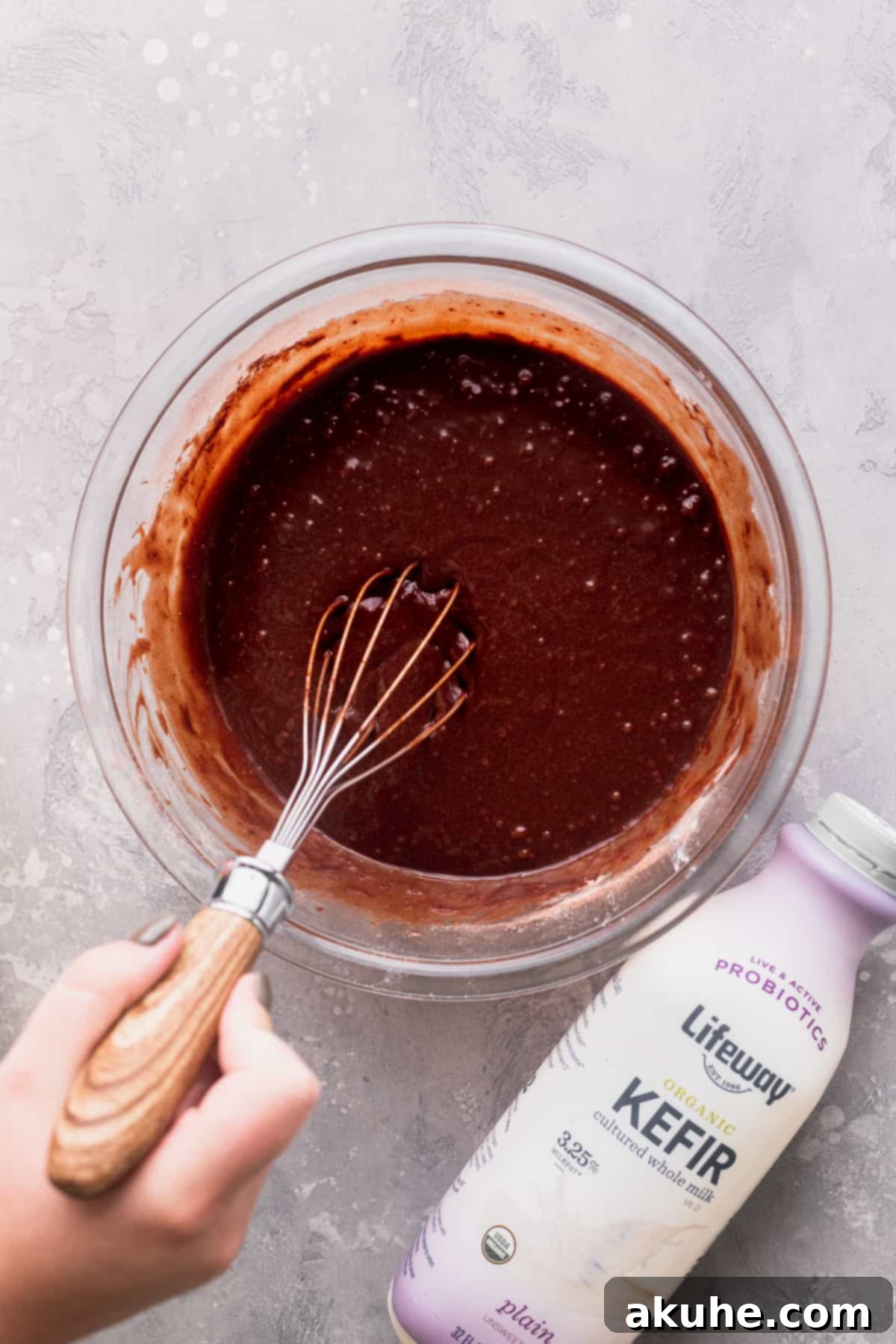Mixing cake batter in a glass bowl until just combined.