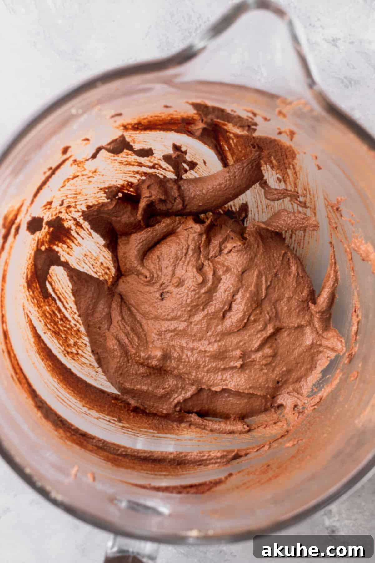 Deep Space Fudge Cookies 5 Rich, glossy melted chocolate being incorporated into the creamed butter and sugar mixture in a glass bowl, creating a smooth chocolate base.