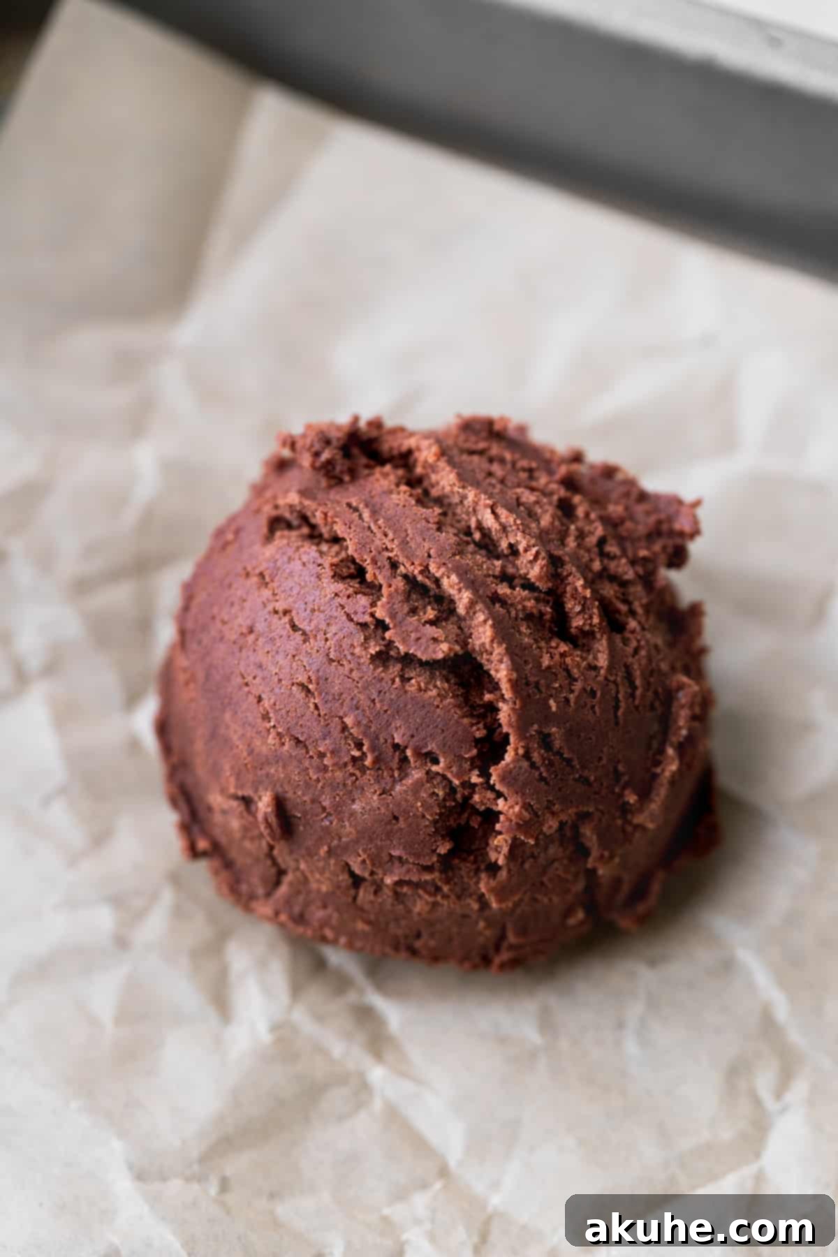 Deep Space Fudge Cookies 8 Uniform balls of chocolate cookie dough neatly arranged on a parchment-lined cookie sheet, ready for baking.