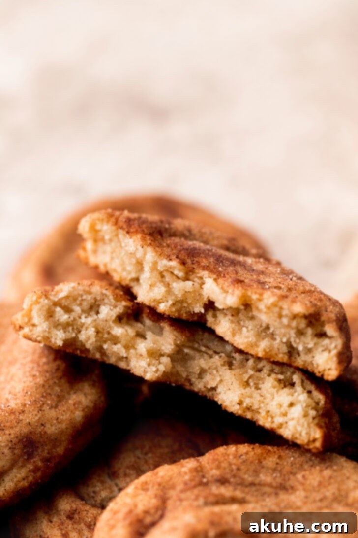 A brown butter snickerdoodle cookie expertly split in half, revealing its chewy interior.