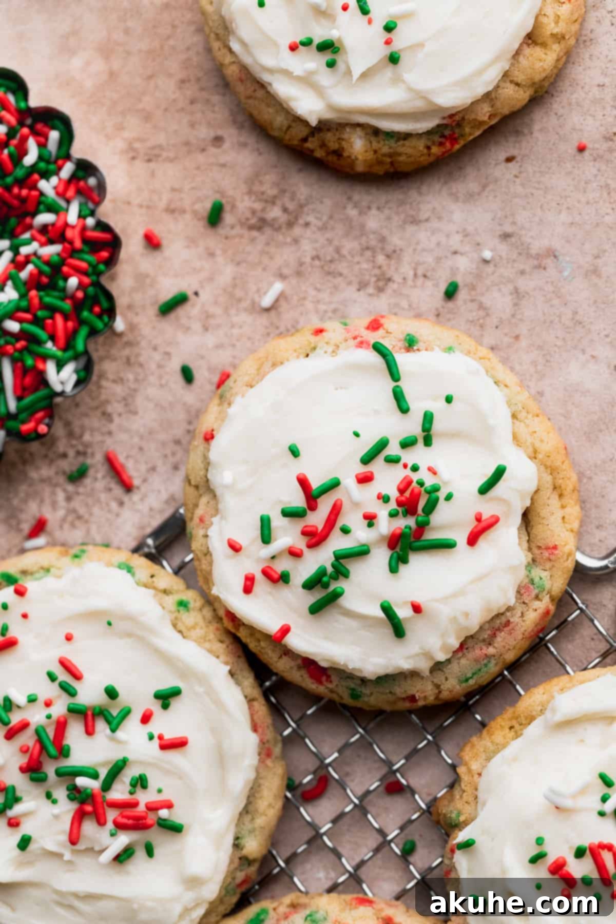 Merry & Bright Sprinkle Cookies 2 Close up of perfectly baked and frosted Christmas sprinkle cookies, showcasing their vibrant red and green sprinkles and soft texture.