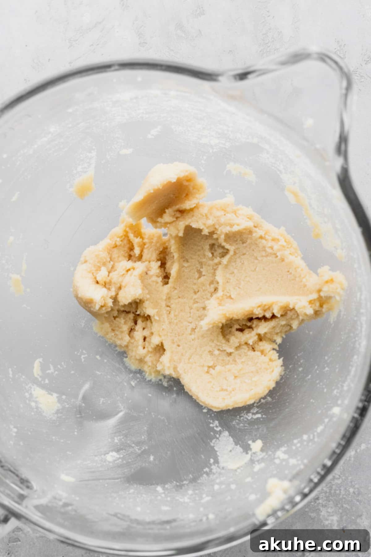 Merry & Bright Sprinkle Cookies 4 Beaten butter and sugar in a glass bowl, showcasing the light and fluffy texture.