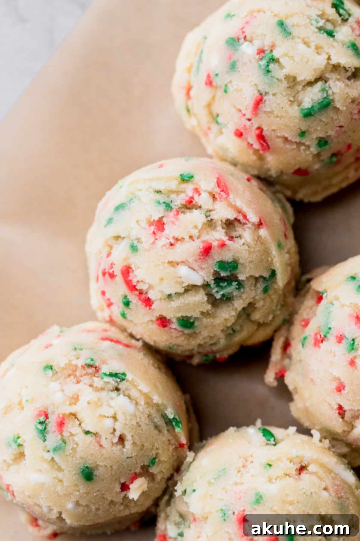 Merry & Bright Sprinkle Cookies 6 Scooped cookie dough balls arranged on parchment paper on a baking sheet.