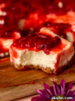 Strawberry Cheesecake Squares 10 A delicious strawberry cheesecake bar with a bite missing.