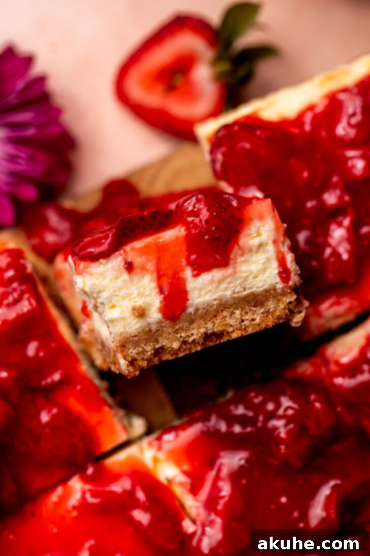 Strawberry Cheesecake Squares 3 A single piece of strawberry cheesecake bar, presented beautifully on its side.