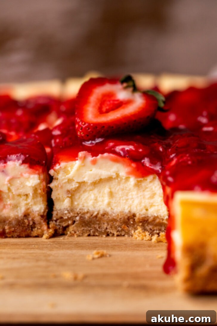 Strawberry Cheesecake Squares 9 Side view of a perfectly baked cheesecake bar, showing distinct layers.