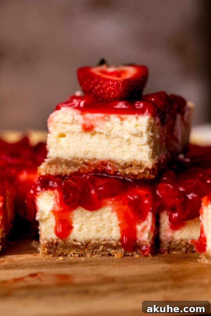Strawberry Cheesecake Squares 11 A stack of two strawberry cheesecake bars, showcasing their generous topping.