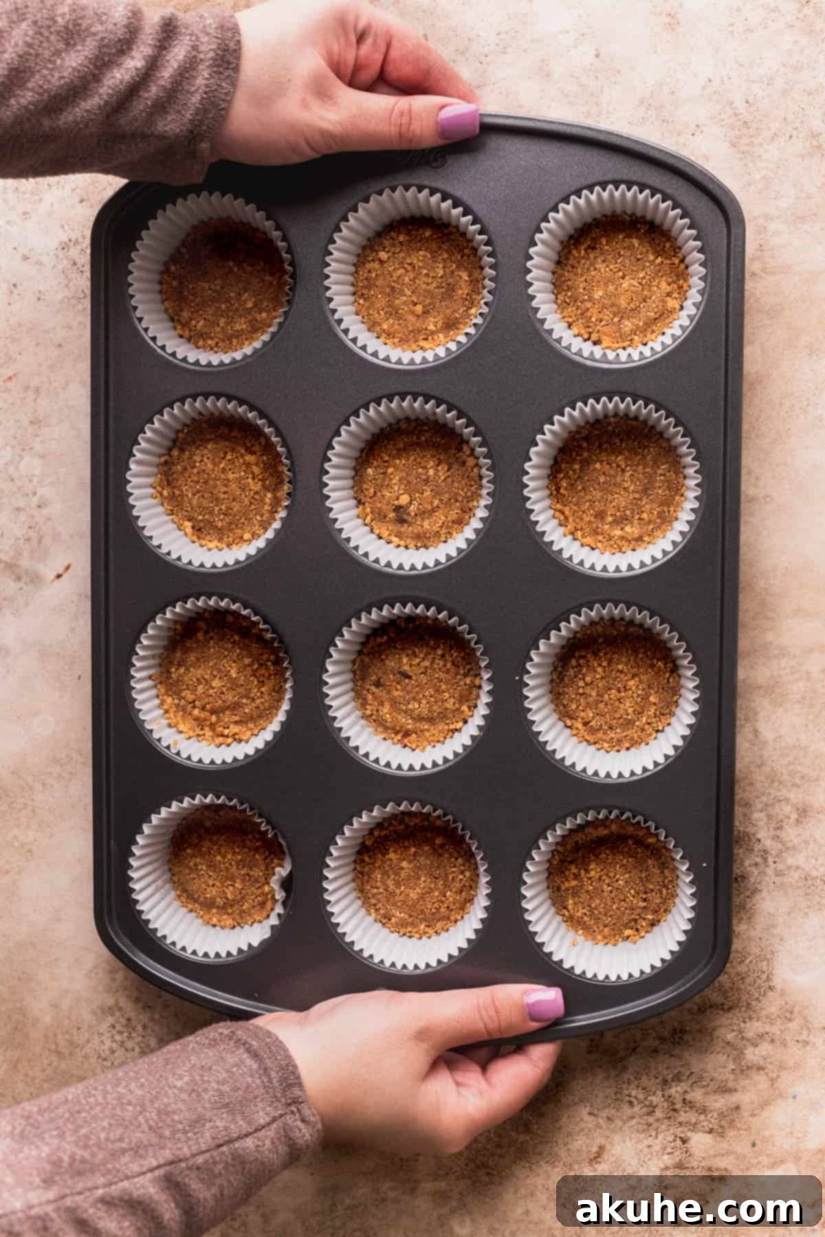 Holiday Gingerbread Cheesecake Delights 4 Graham cracker crust in a muffin pan.