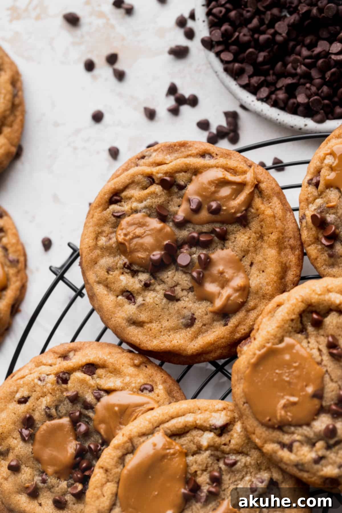 Freshly baked Biscoff butter cookies cooling on a wire rack, showcasing their golden edges and melted Biscoff pools.