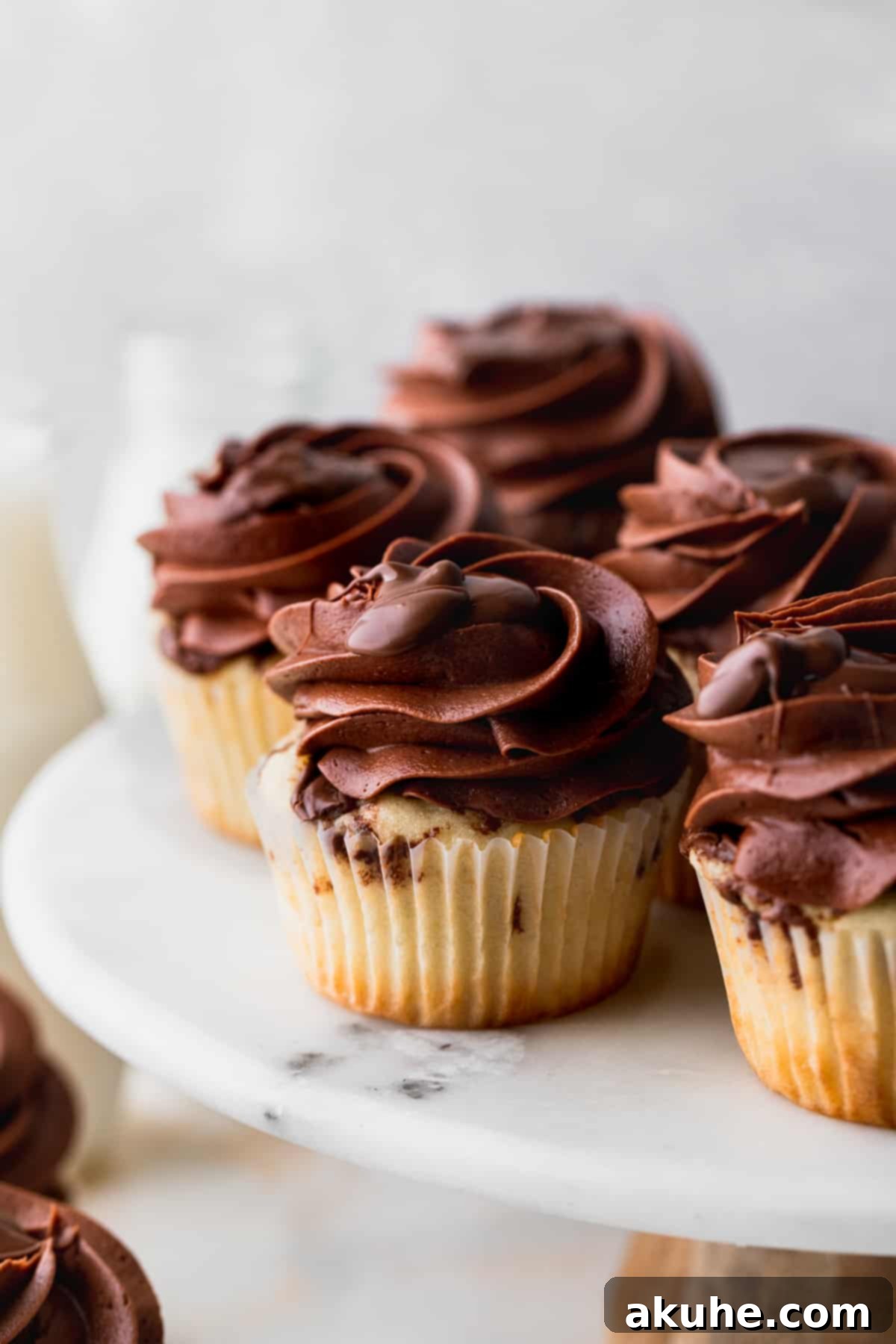 Irresistible Vanilla Nutella Cupcakes 3 A collection of easy vanilla Nutella cupcakes arranged artfully on a cake stand, their rich frosting inviting a taste.