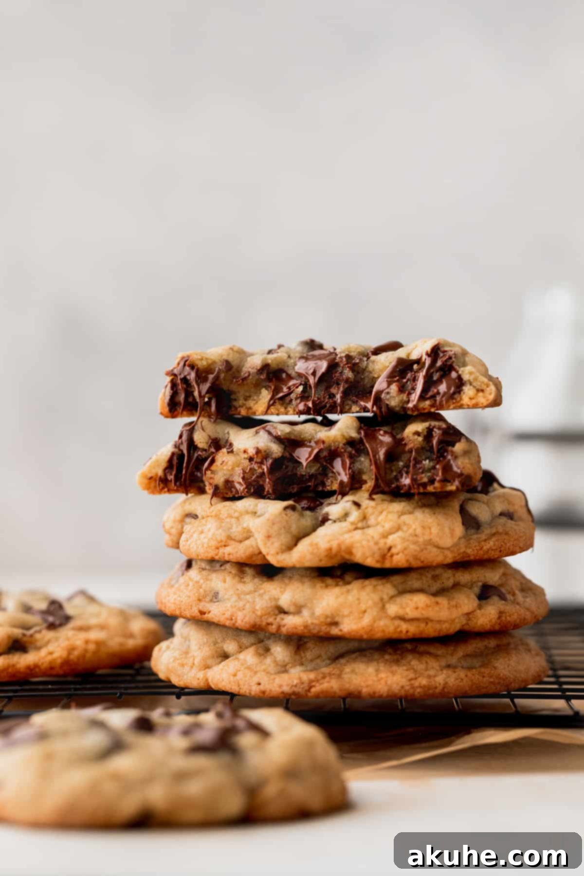 Just Enough Chocolate Chip Bliss 9 A stack of perfectly baked small batch chocolate chip cookies, with one cookie broken in half to show its soft interior and melted chocolate.