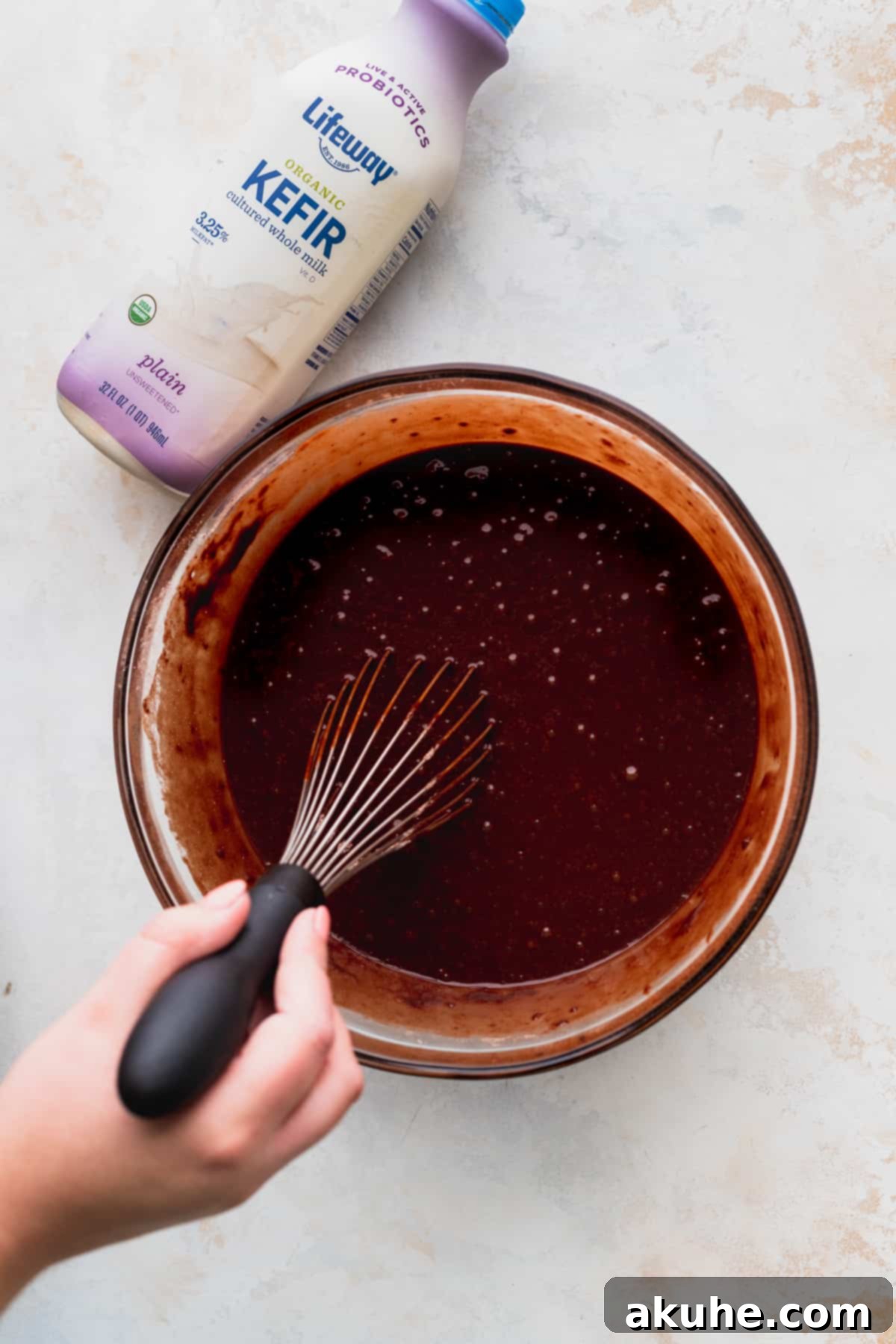 Blueberry Chocolate Layer Cake 5 Chocolate cake batter being mixed to a perfect consistency in a transparent glass bowl, ready for baking.