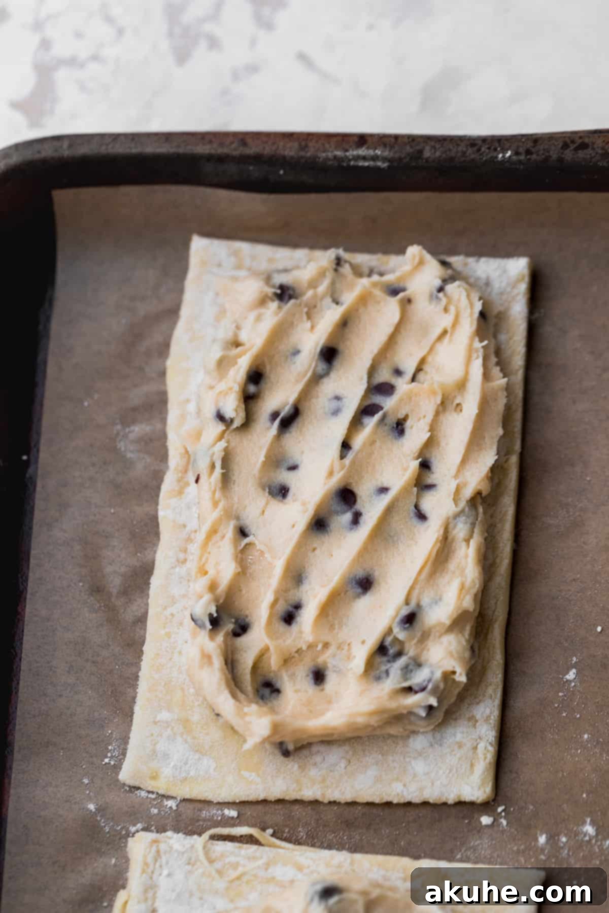 Ultimate Chocolate Cookie Dough Pop Tarts 8 Cookie dough filling spread onto puff pastry rectangle, leaving edges clear.