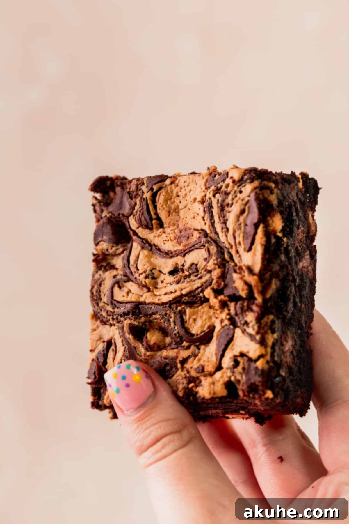 Holding up a chocolate peanut butter brownie.