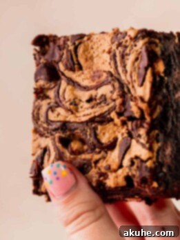 Holding up a chocolate peanut butter brownie.