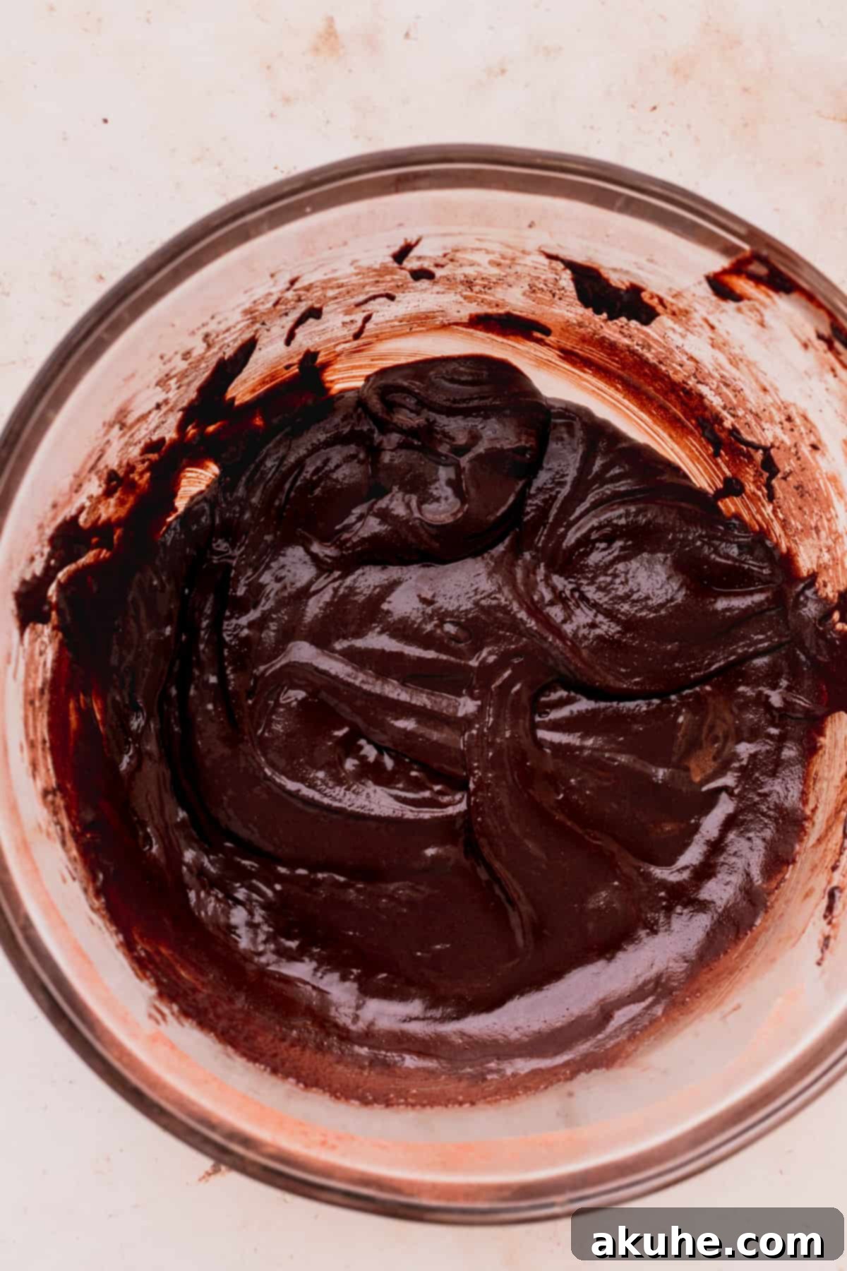 Chocolate brownie batter in a glass bowl.