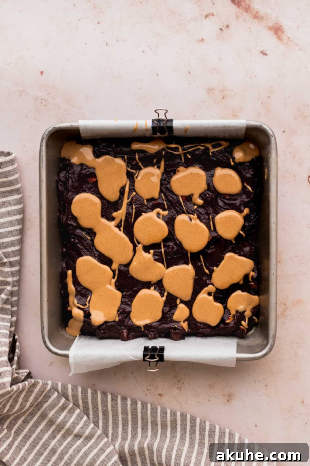 Peanut butter dollops on top of brownie batter.