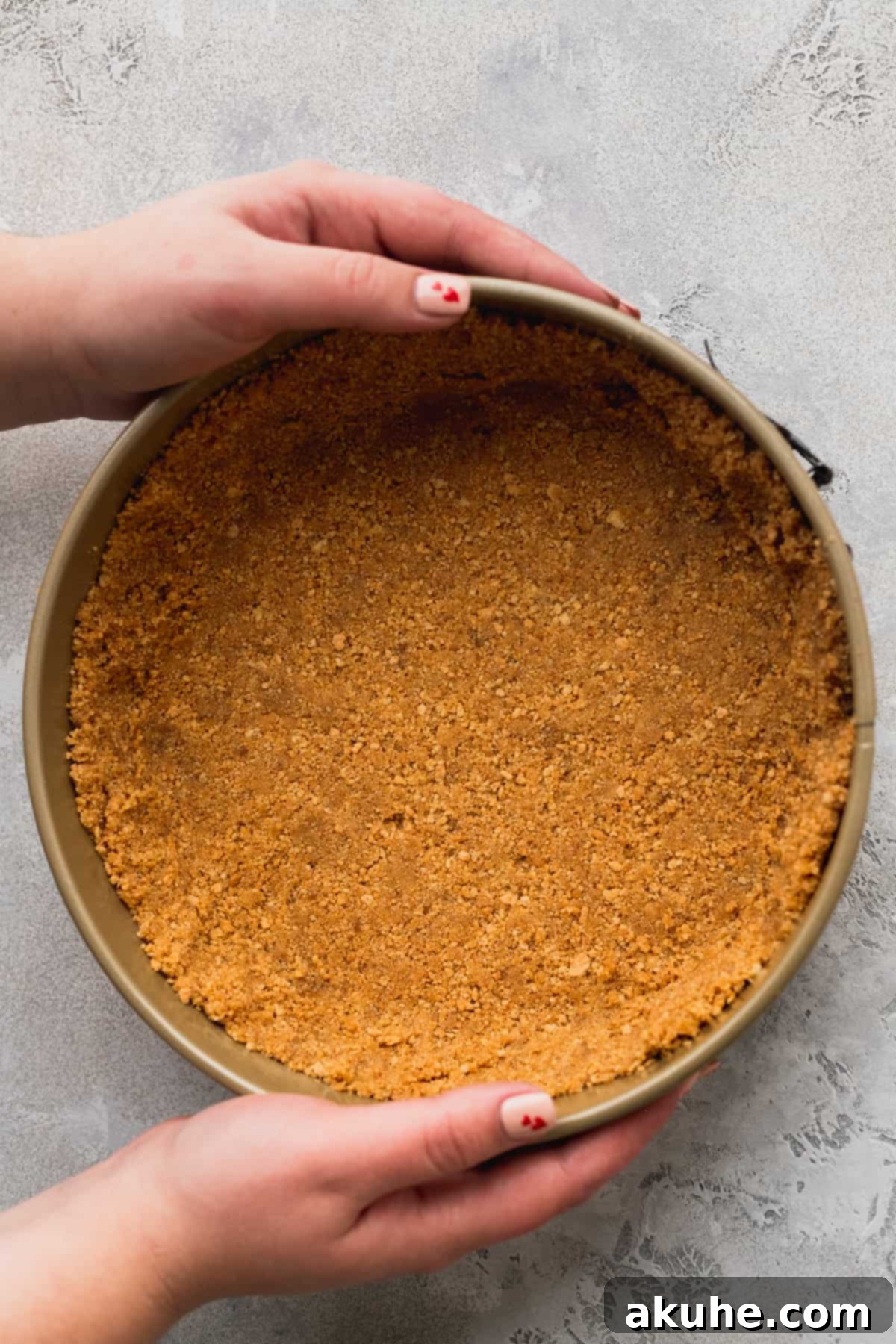 Decadent White Chocolate Cheesecake 4 Graham cracker crust meticulously pressed into a springform pan, ready for baking.