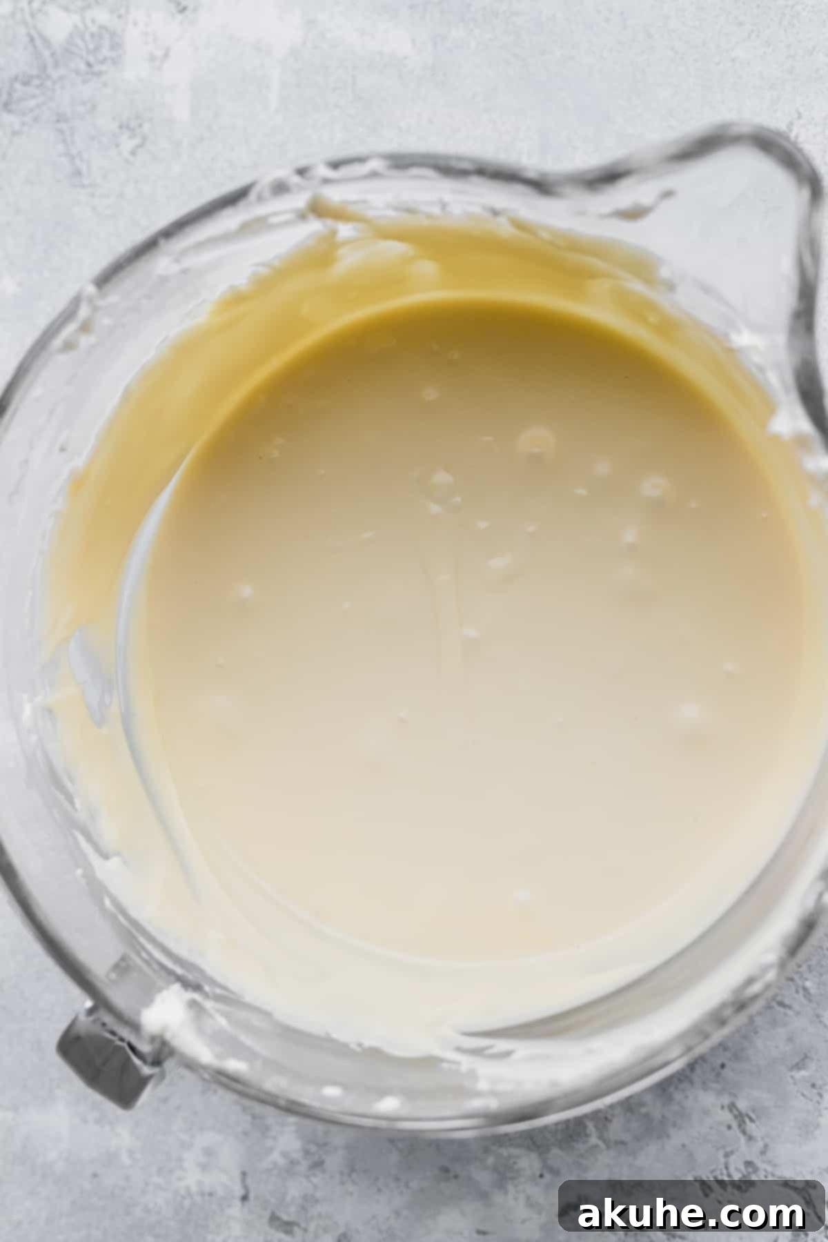 Decadent White Chocolate Cheesecake 6 Lush, pale yellow cheesecake batter in a glass bowl, ready to be poured.