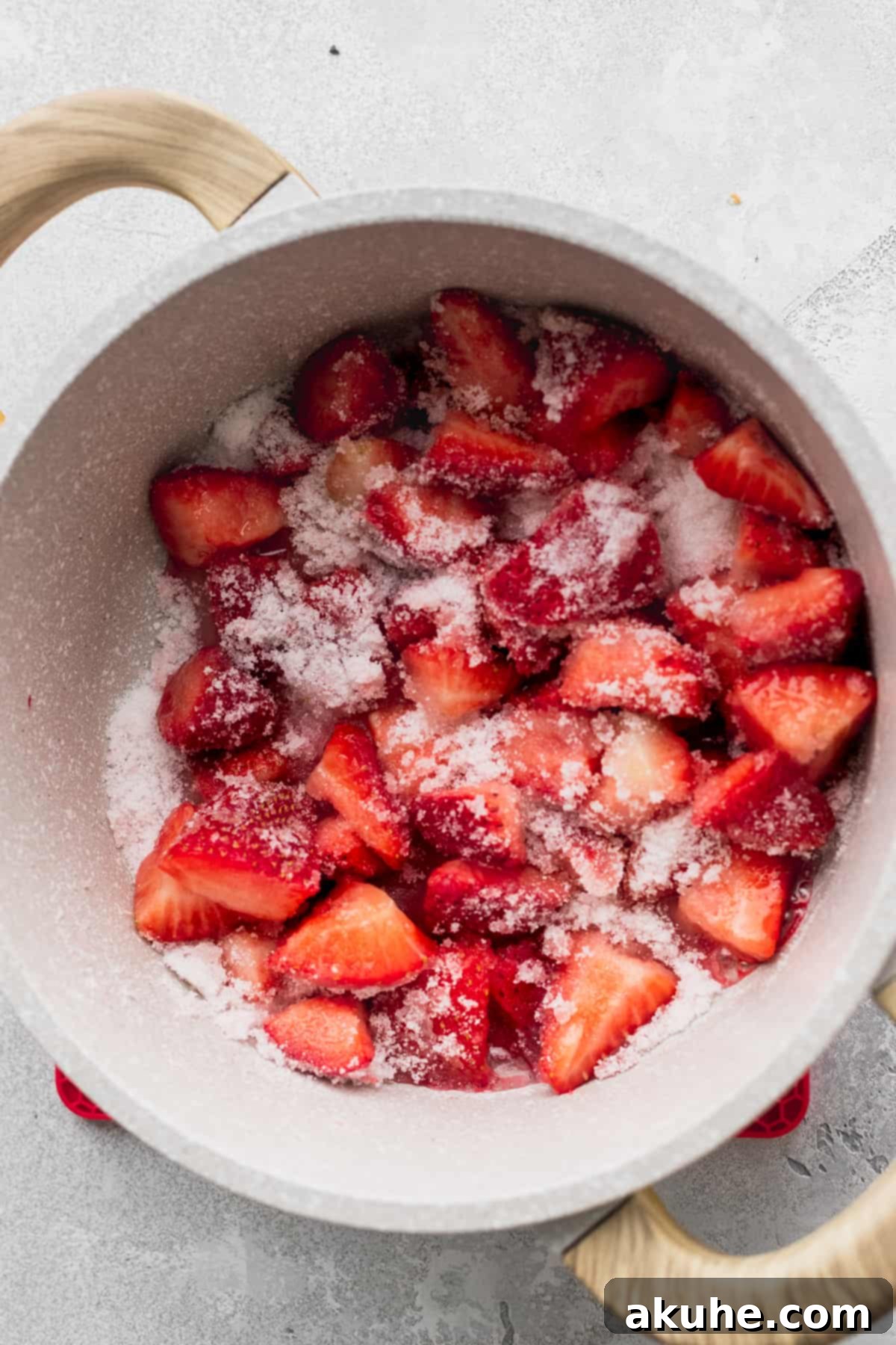 Decadent White Chocolate Cheesecake 9 Fresh strawberries covered in granulated sugar simmering in a pot on the stovetop.