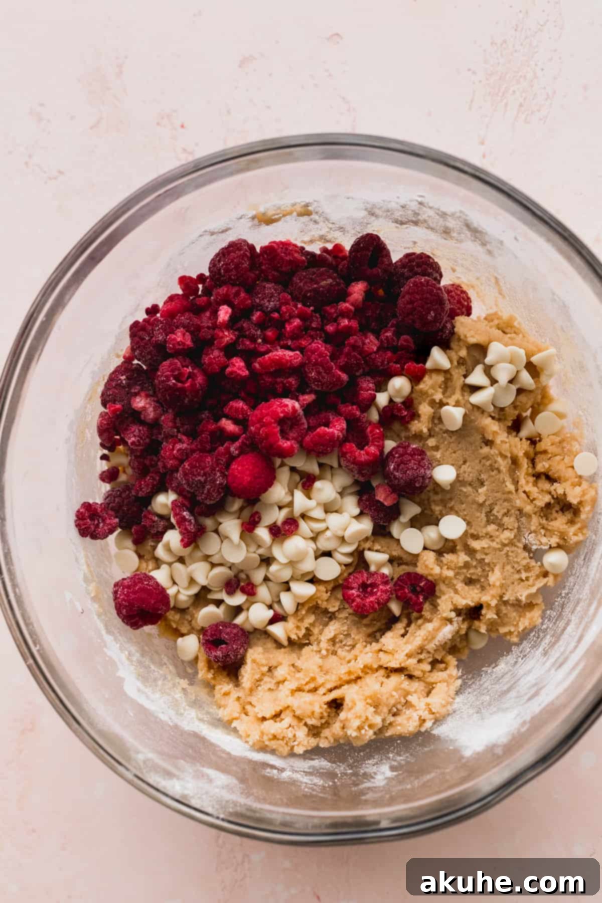 Raspberry White Chocolate Chip Cookies 5 Dry ingredients (flour, baking powder, soda, salt) in a glass bowl with fillings on top.