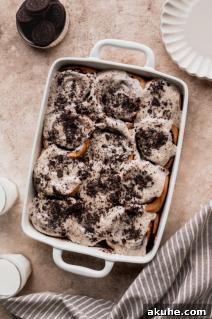 Freshly baked Oreo cinnamon rolls cooling in a pan, showcasing their golden-brown tops and rich glaze.