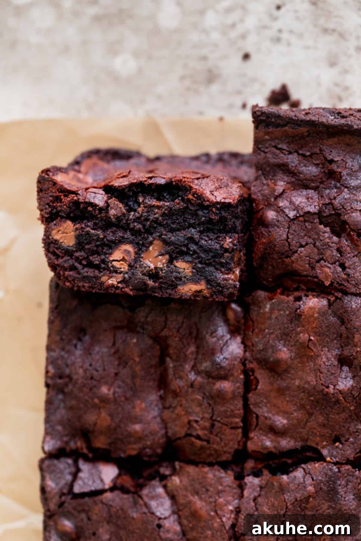Artisan Brownie Bites 2 Close up of small batch fudgy brownies with one on it's side, showcasing their thick, rich texture.