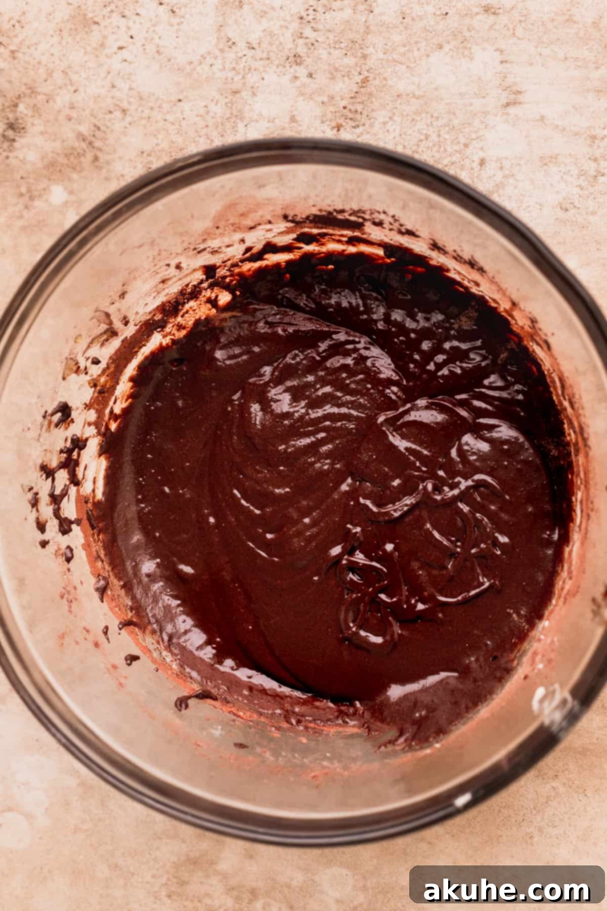 Artisan Brownie Bites 5 Brownie batter with dry ingredients added in a glass bowl, showcasing the rich color.