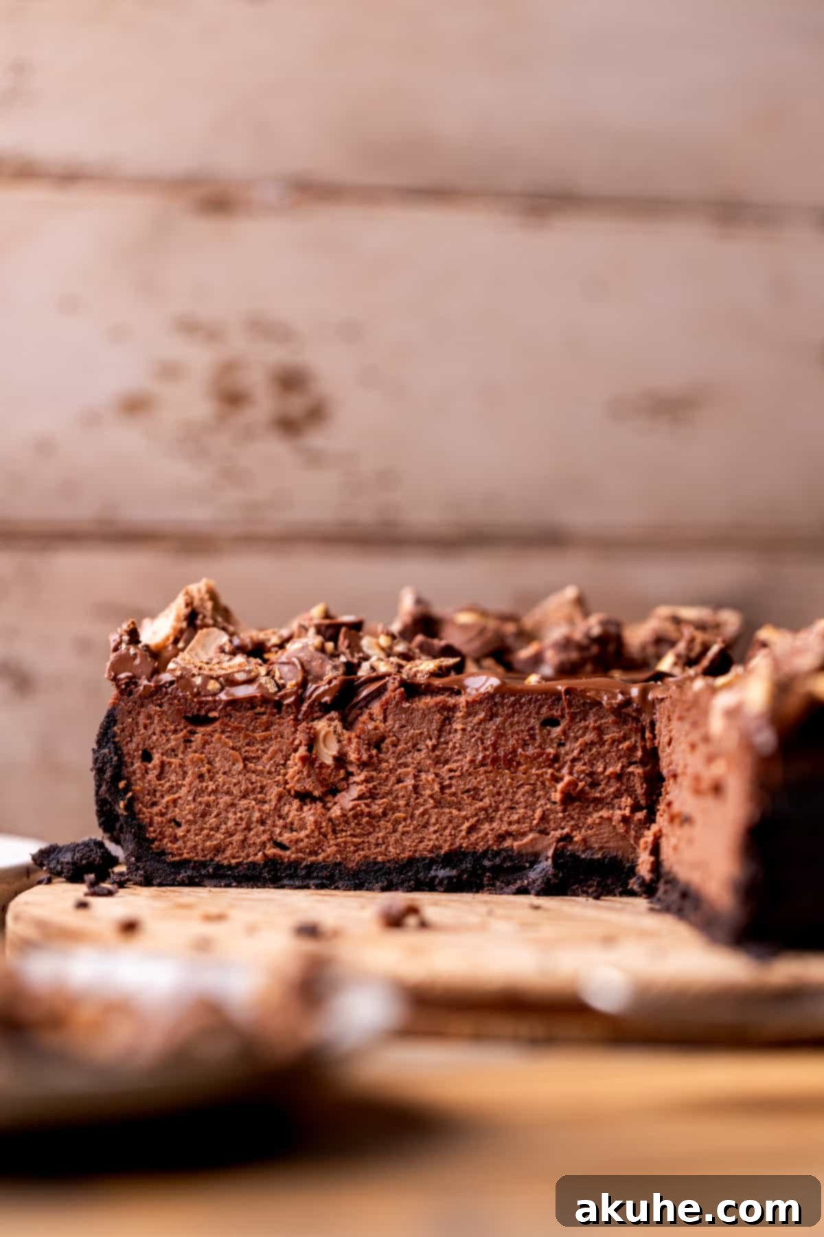 Decadent Nutella Cheesecake 3 A freshly baked and cooled Nutella cheesecake, ready to be sliced, on a dark platter.