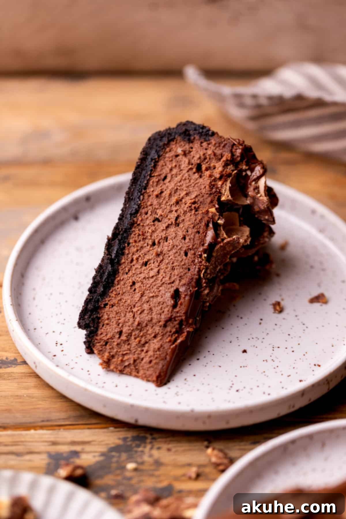 Decadent Nutella Cheesecake 9 A perfect slice of Nutella cheesecake with Ferrero Rocher topping, on a white plate, ready to be enjoyed.