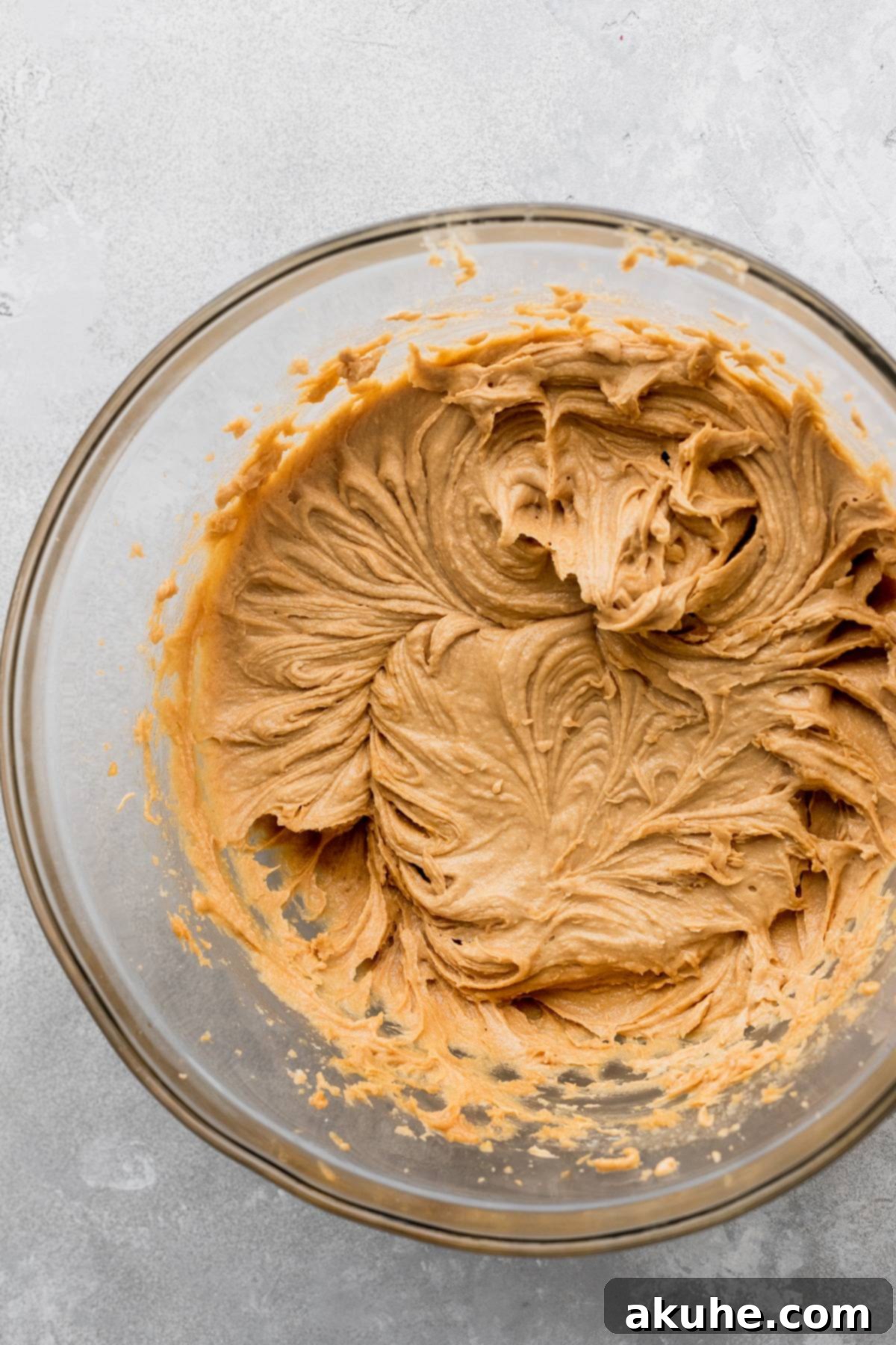 Decadent Peanut Butter Nutella Cookies 4 Wet ingredients whipped to a creamy consistency in a clear glass mixing bowl, ready for dry ingredients.
