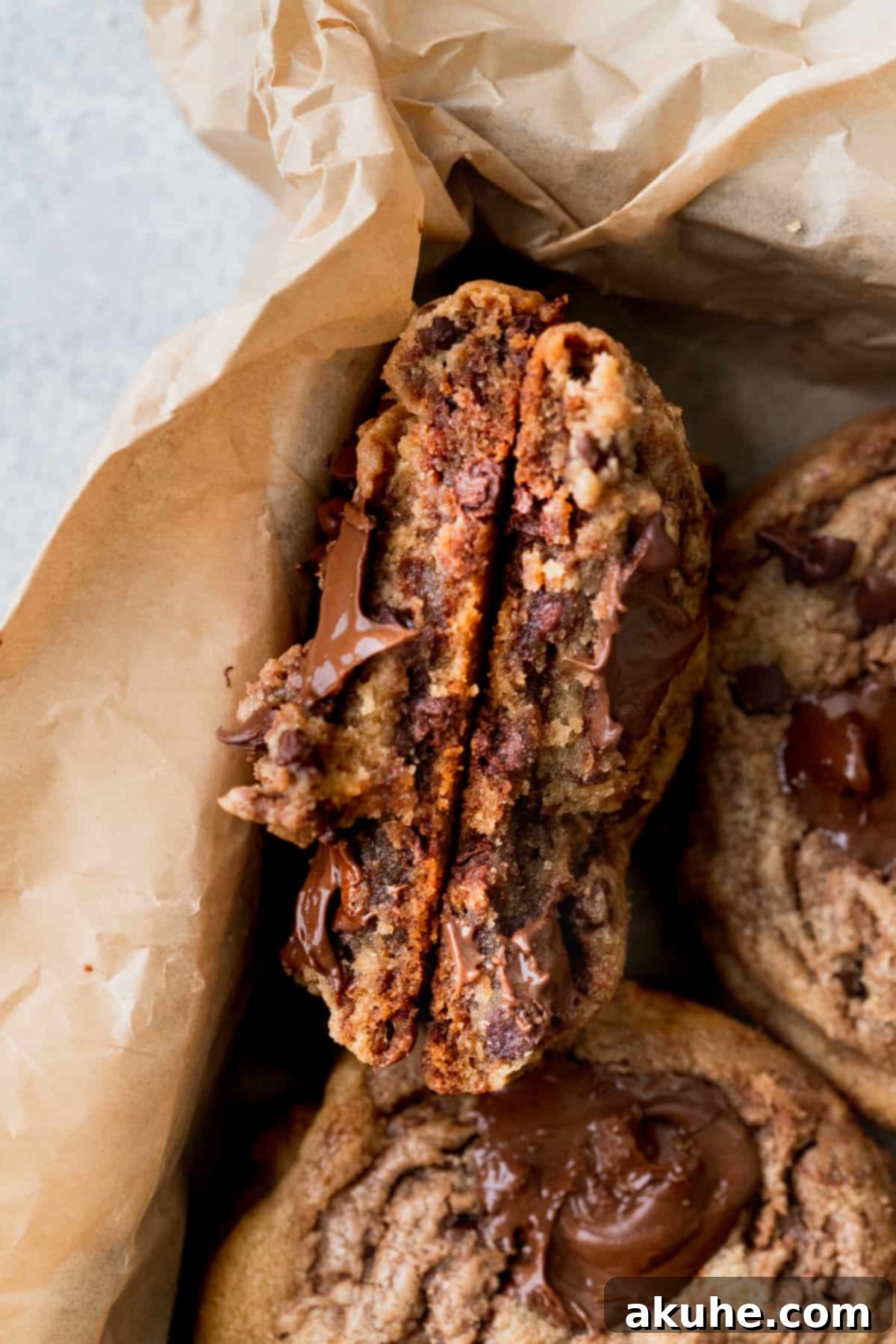 Decadent Peanut Butter Nutella Cookies 10 A peanut butter Nutella cookie torn in half inside a cookie box, revealing its chewy interior and gooey Nutella center.