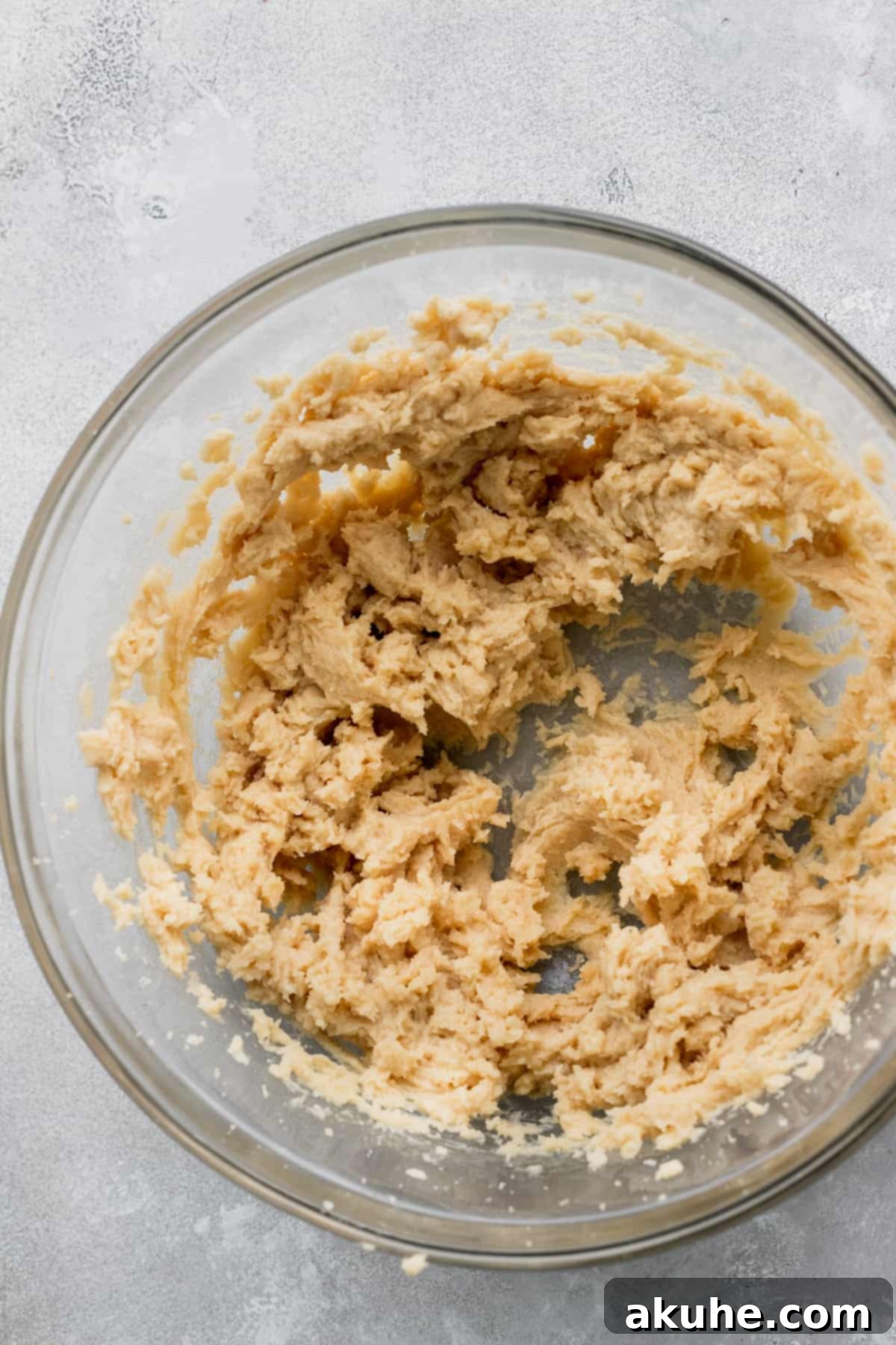 Celebratory Cookie Confections 4 Close-up of the perfectly combined wet ingredients in a clear glass mixing bowl, showcasing their smooth and creamy texture.