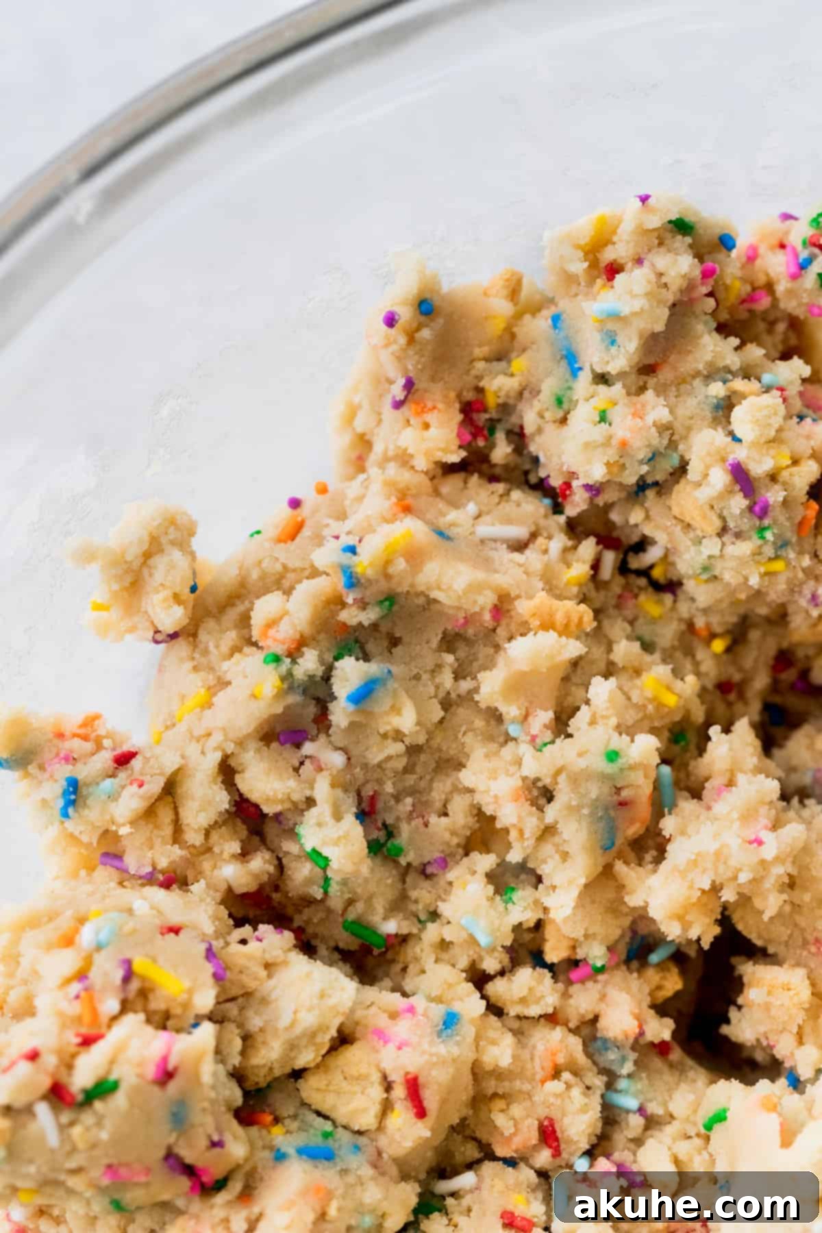 Celebratory Cookie Confections 6 An appetizing close-up of the completed cookie dough, speckled with colorful sprinkles and golden Oreo bits, ready for scooping.