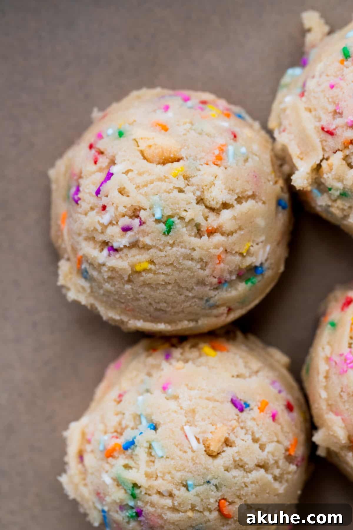 Celebratory Cookie Confections 7 Neatly scooped cookie dough balls, studded with sprinkles and Oreo pieces, arranged on a parchment-lined baking sheet, chilling for perfect baking.