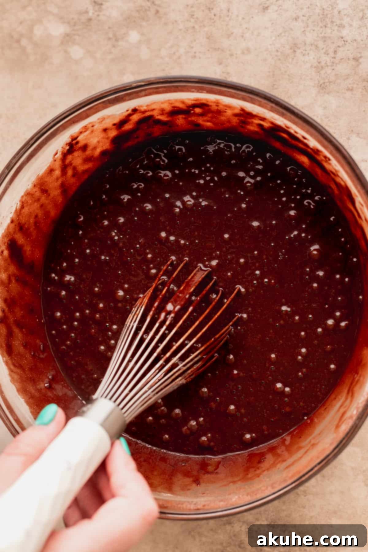 Andes Mint Chocolate Cake 5 Stirring chocolate cake batter in a glass bowl.