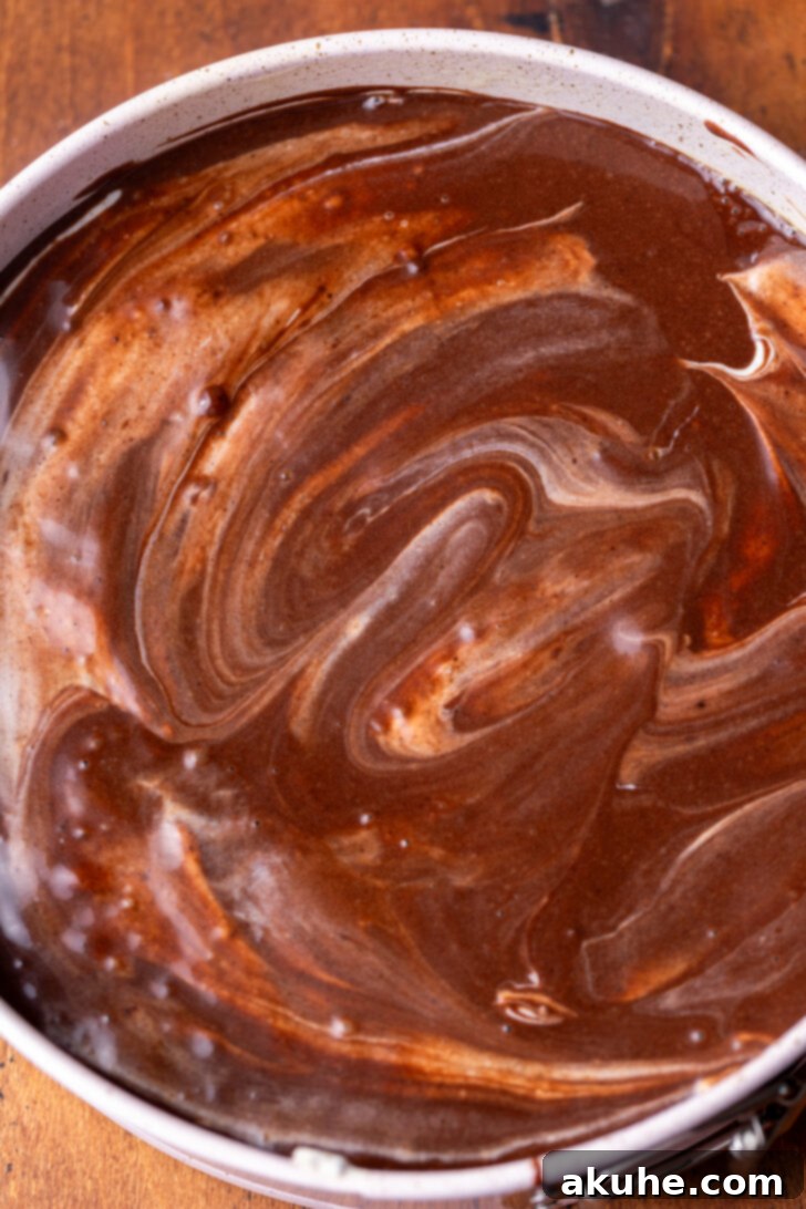 Oreo Dream Cheesecake 7 Chocolate cake batter spread as the final layer on top of the cheesecake.