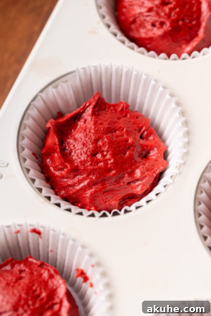 Red Velvet Delight 5 Red velvet cake batter poured into a cupcake pan with liners.