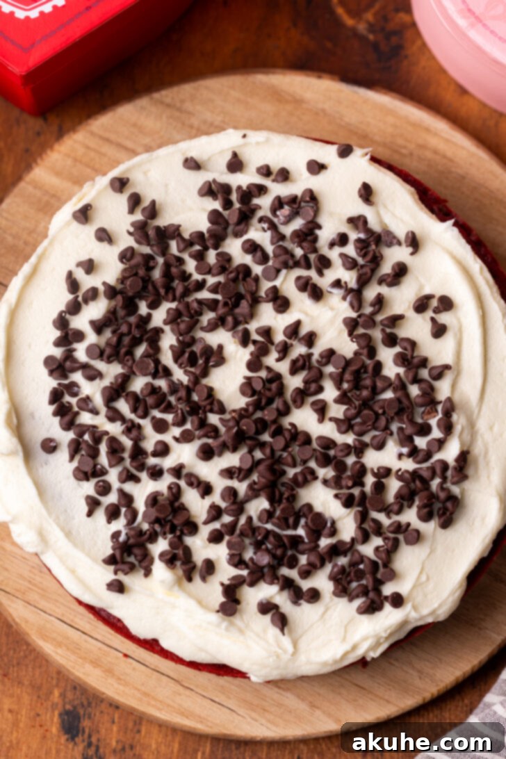 Cream cheese frosting being spread on top of a cake layer.
