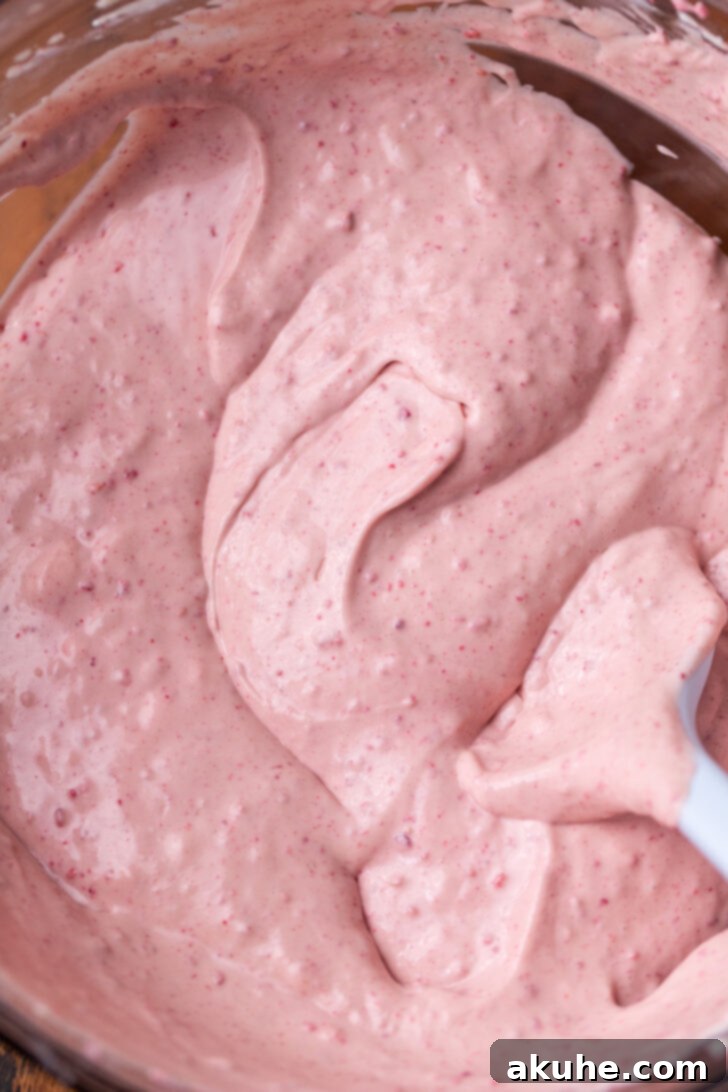 A close-up of the raspberry cheesecake batter in a bowl, showing its creamy texture and flecks of raspberry.