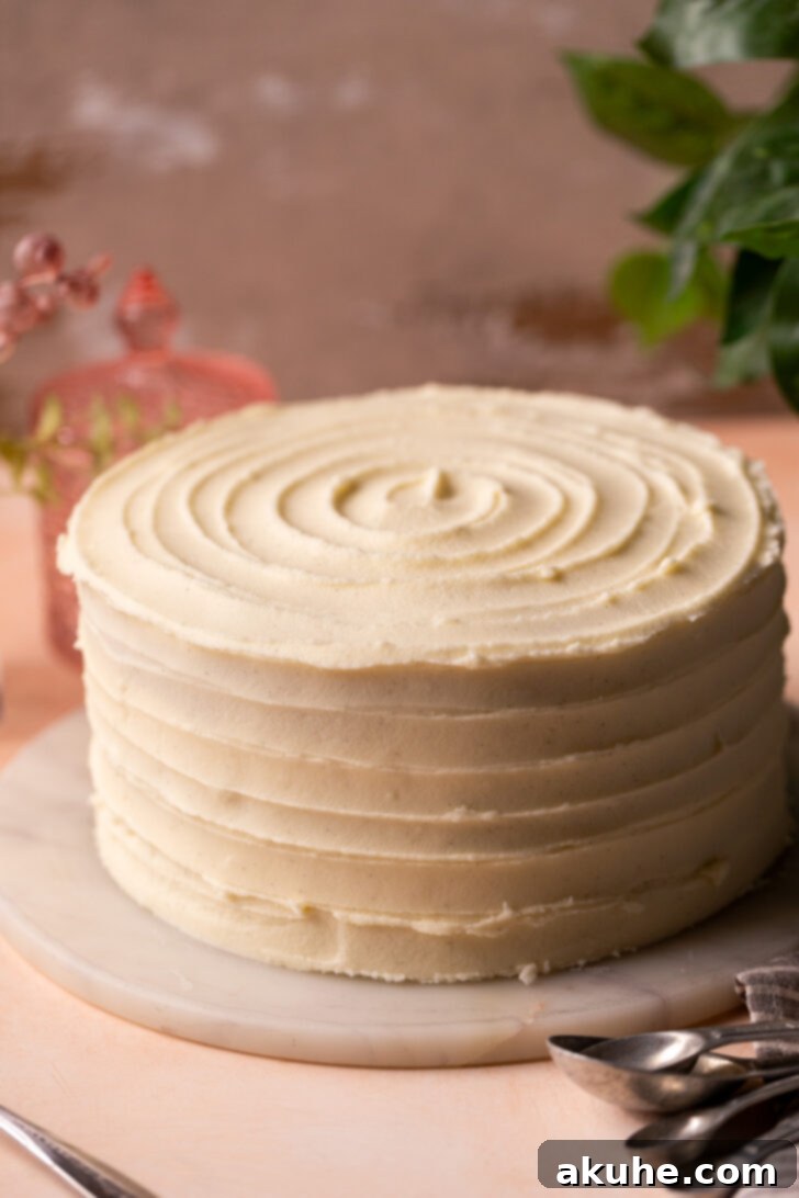 The Ultimate Vanilla Cake Experience 7 A beautifully decorated vanilla cake with a swirl pattern on a marble board.